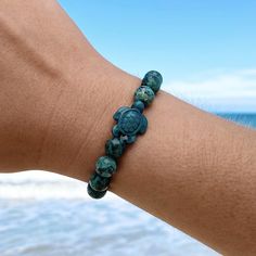 Simple and playful, the nautically-inspired Granite Bead Sea Turtle Bracelet can be paired with any outfit to create a stylish, elegant look.  Remind your favorite beach-lover of their happy place with this memorable bracelet.  Details: Assorted Granite Beads, 8mm In Diameter  Stretchable Size Fits All  Sunshine on your neck, the ocean in your ears. Discover GoBeachy jewelry - where summer never fades. Dive into sun-kissed sparkle, where quality meets coastal charm. GoBeachy jewelry isn't just an accessory, it's a portal to your inner mermaid. Each piece whispers of waves, shimmers with the ocean's kiss, and dances with the shoreline's carefree spirit. We craft our treasures with passion, using materials that hold the weight of your adventures and sparkle that ignites your spirit. Whether Turquoise Anklet, Sea Turtle Bracelet, Turtle Bracelet, Turtle Charm, Coastal Charm, Summer Bracelets, Beach Lover, Ocean Lover, Message Jewelry