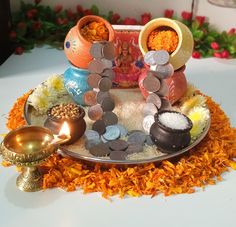 an assortment of different items on a plate with flowers in the background and candles lit