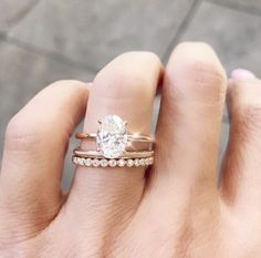 a woman's hand with two different rings on it and one has a diamond in the middle