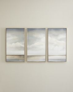 three paintings hang on the wall in an empty room