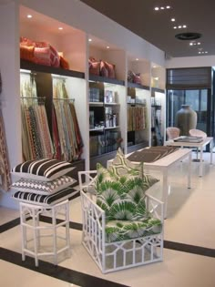 the interior of a clothing store with chairs and rugs