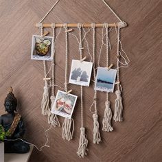 a wall hanging with pictures and rope attached to it's sides next to a small buddha statue