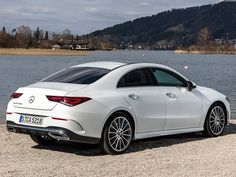 a white car parked next to a body of water