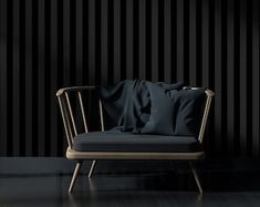 a chair with pillows on it in front of a black striped wall