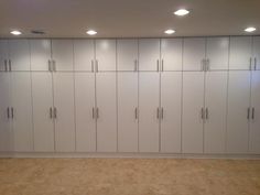 an empty room with white cabinets and lights