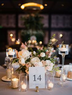 the table is set with candles, flowers and menu cards for an elegant wedding reception