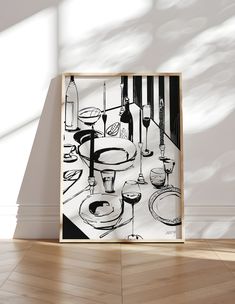 a black and white painting on a wall next to a table with wine glasses, plates and utensils