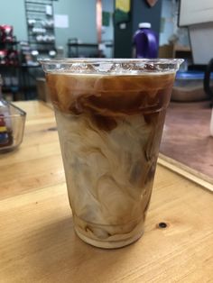 a cup filled with liquid sitting on top of a wooden table