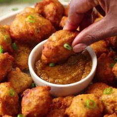 a person dipping sauce into some fried food