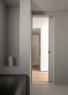 an open door leading to a bathroom with white walls