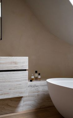 a white bath tub sitting under a bathroom mirror