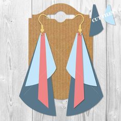 pair of earrings with pink, blue and grey color blockings on wooden board background