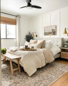 a bedroom with a bed, rug and ceiling fan