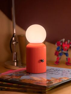 The Skittle lamp is new for 2022! The unique design takes inspiration from Lund's iconic Skittle bottle and has lots of fun features. The silicone bulb has 8 color settings and it's wireless so can easily be used anywhere. With a wireless phone charger included, this is the perfect bedside duo. Details:Wireless.Charge Cool Unique Lamps, Counter Lamp Kitchen, Mid Century Modern Table Lamp, Blender Inspiration, Wireless Lamp, Mcm Lamp, Fun Lamp, Eclectic Lamps, Wireless Lighting