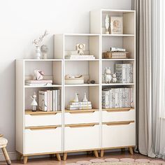 a white bookcase filled with lots of books next to a window