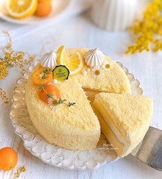 there is a cake on the plate with lemons and oranges around it that has been cut into pieces