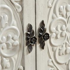 two black and white flowers are on the side of an ornately decorated cabinet door