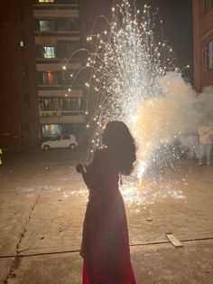 a woman is looking at fireworks in the street