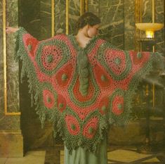 a woman wearing a red and green crocheted shawl