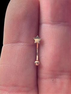 a tiny gold nose ring with a star on it