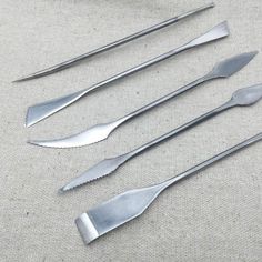 five silverware utensils laid out on a table