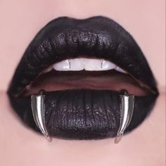 a woman's lips with black lipstick and horns on the tip of her lip