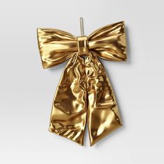 a gold bow is hanging on a white wall