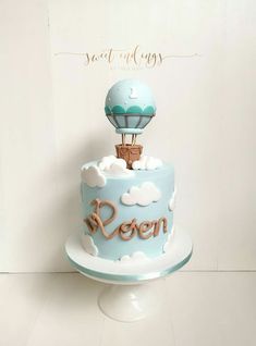 a blue and white cake with an air balloon on top