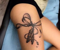 a woman's arm with a tattoo on it that has a bow and feathers