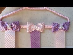 three pink and purple bow ties hanging on a wall