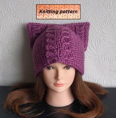 a close up of a doll head wearing a knitted cat ear hat with the words knitting pattern above it