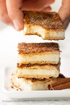 three pieces of cheesecake stacked on top of each other with cinnamon sticks sticking out of them