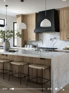 an image of a kitchen setting with stools in the foreground and on the right