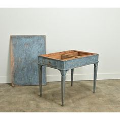 an old blue table with a drawer on it