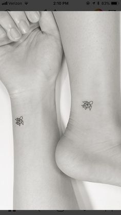 two people with matching tattoos on their feet, one is holding the other's leg