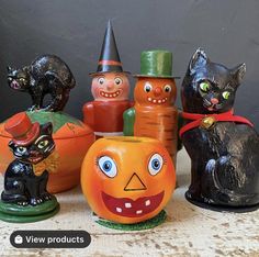 a group of halloween pumpkins with cats and witches painted on them, sitting next to each other