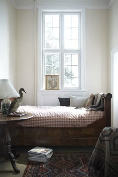 a bedroom with a bed, lamp and window