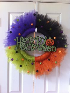 a colorful wreath with the words happy halloween hanging on it's front door,