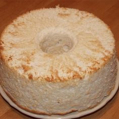 a bundt cake sitting on top of a white plate next to a wooden table