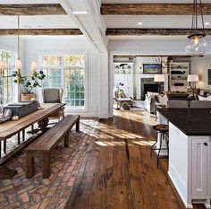 a large open concept living room with wood flooring and exposed beams in the ceiling