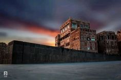 an image of a building that is in the sky at sunset or dawn with clouds