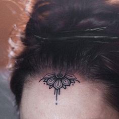 a woman's head with a tattoo on the top of her head and behind her ear