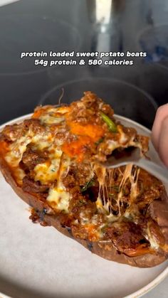 a person is holding a slice of pizza on a plate with the words protein loaded sweet potato boats