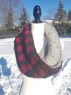 a white mannequin with a red and black scarf on it