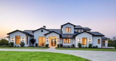 a large white house sitting on top of a lush green field