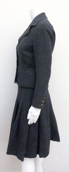 "This is a good quality couture suit by Lachasse London. It was most likely made during the late 1940's. The piece has the same construction as a Hardy Aimes suit I own from the same period. It's made from wool which has purple and green tones. The jacket is three-buttoned with a nipped in waist. The two small pockets on the front of the jacket sit neatly on the waist. The skirt is pleated though the pleats have lost some of their crispness. It zips up at the side and has a small hook and eye cl Retro Fitted Skirt Suit For Tailoring, Fitted Tweed Jacket With Button Cuffs For Work, Vintage Fitted Tweed Jacket For Formal Occasions, Fitted Tweed Jacket With Button Cuffs For Tailoring, Formal Fitted Tweed Jacket With Buttons, Fitted Wool Tweed Jacket With Button Cuffs, Fitted Vintage Tweed Jacket For Work, Vintage Fitted Tweed Jacket For Office, Vintage Fitted Suits For Office