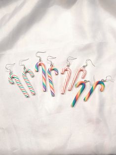 six candy canes are arranged in the shape of letters on a white sheeted surface