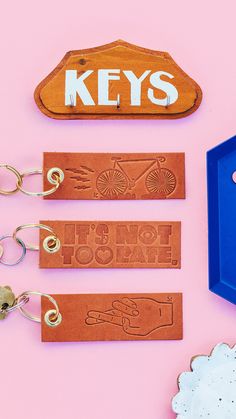 four key chains are attached to the back of a wooden sign that says keys on it