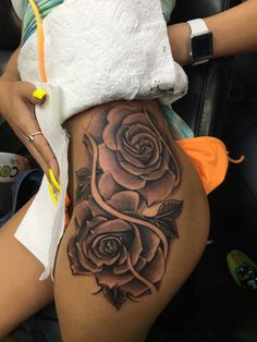 a woman's thigh with a rose tattoo on it