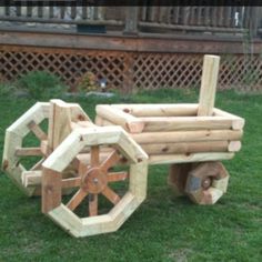 a wooden cart made out of logs in the grass